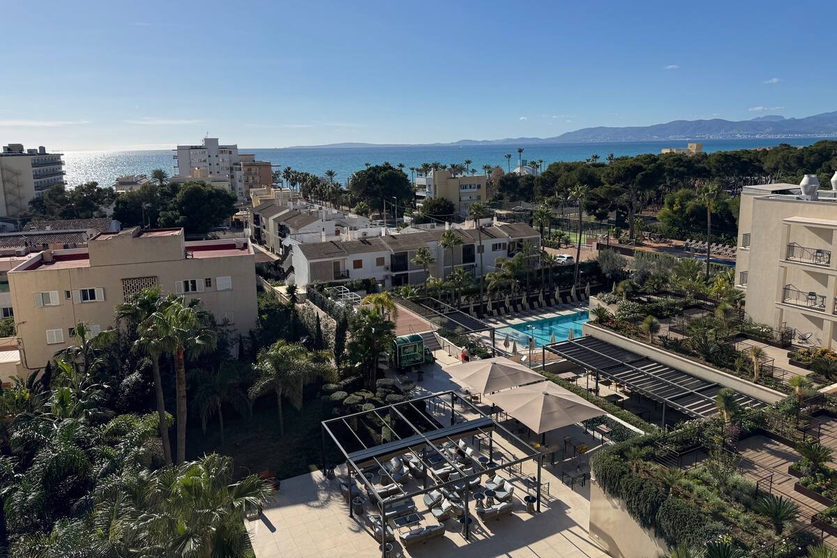 A resort with a pool, outdoor seating, and views of the sea.