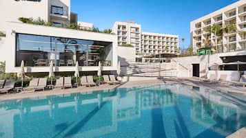 Een binnenzwembad, een buitenzwembad en ligstoelen