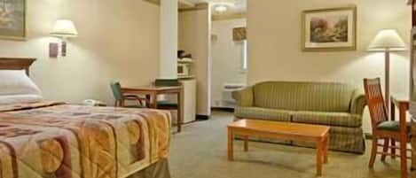 Una habitación de hotel con una cama, un sofá verde, una mesa de centro de madera y un escritorio con una silla.