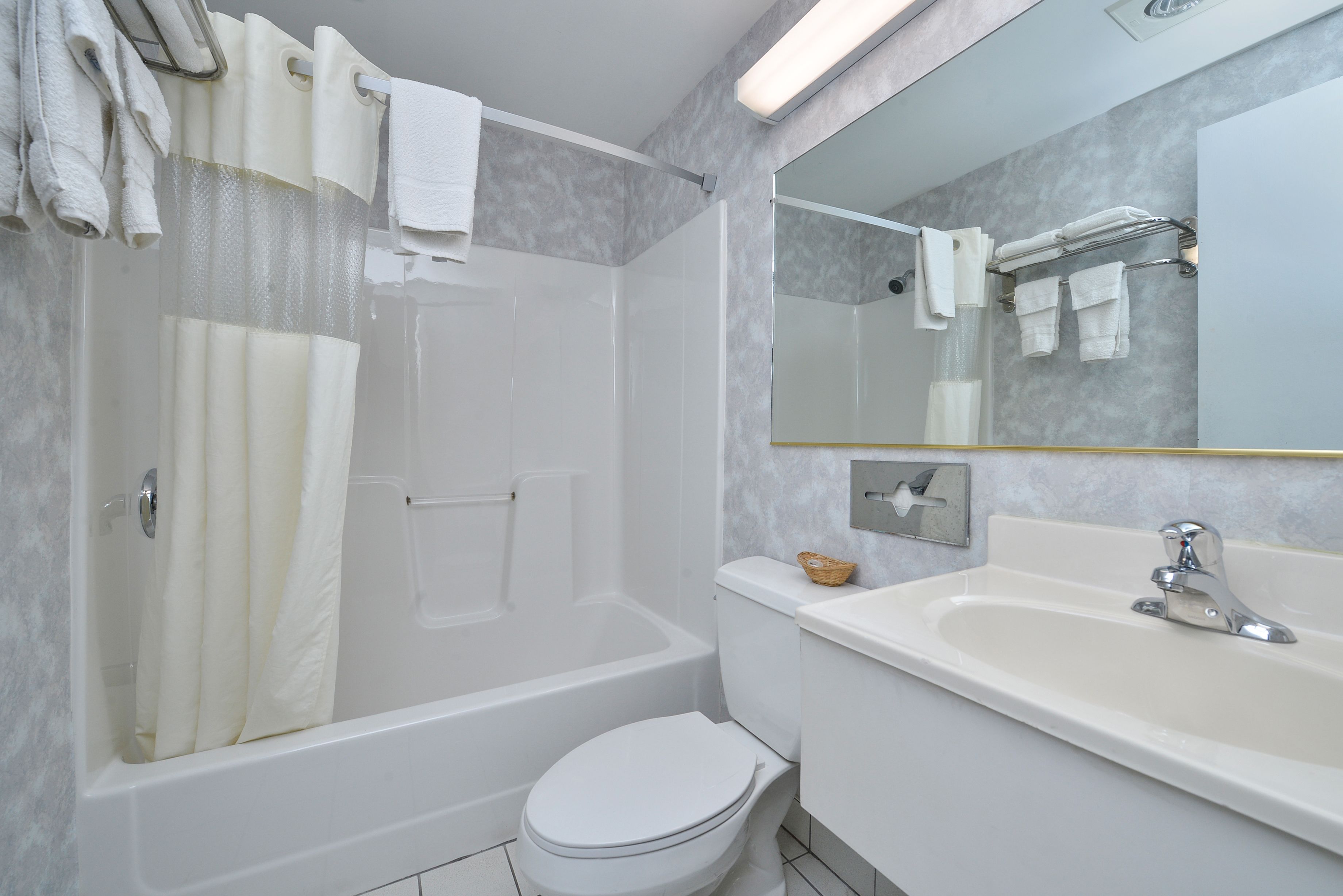A modern bathroom with a bathtub, toilet, and sink.