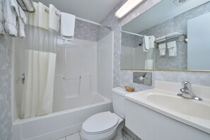 A modern bathroom with a bathtub, toilet, and sink.
