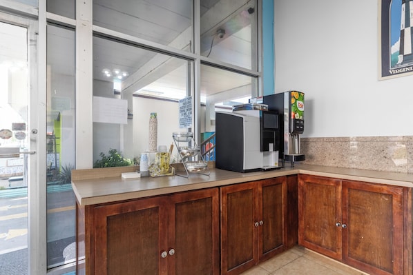 Una cocina con armarios de madera, una cafetera y un refrigerador.