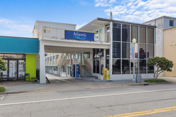 A two-story building with an 'Atlantic Inn' sign, a visible staircase, and a Pepsi vending machine. - Atlantic Inn (Virginia Beach)