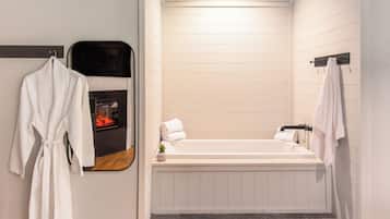 Une salle de bain moderne avec une baignoire, un miroir et un porte-serviettes.