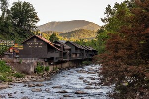 Ein Motorhotel namens Rocky Waters an einem Fluss, mit einem Berg im Hintergrund.