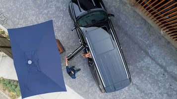 Un vehículo estacionado en una calle adoquinada con un lona azul en el suelo.