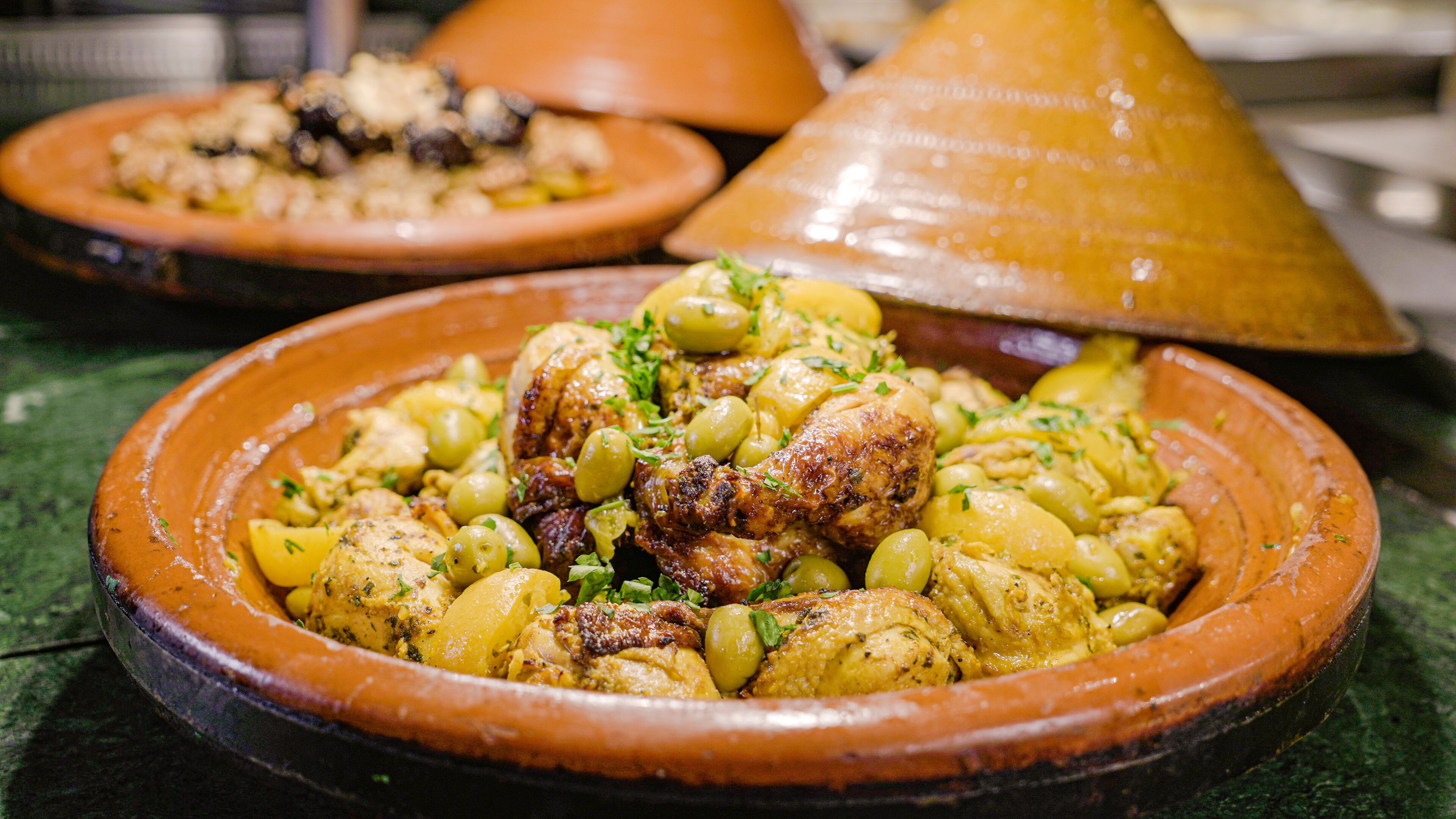 A traditional Moroccan tagine dish with chicken and potatoes, served on a clay plate.