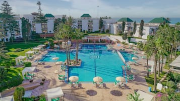 Alberca al aire libre, sombrillas en la alberca y camastros