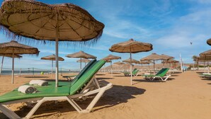 A beach with rows of sun loungers and thatched umbrellas. - AGADIR BEACH CLUB HOTEL (Agadir)