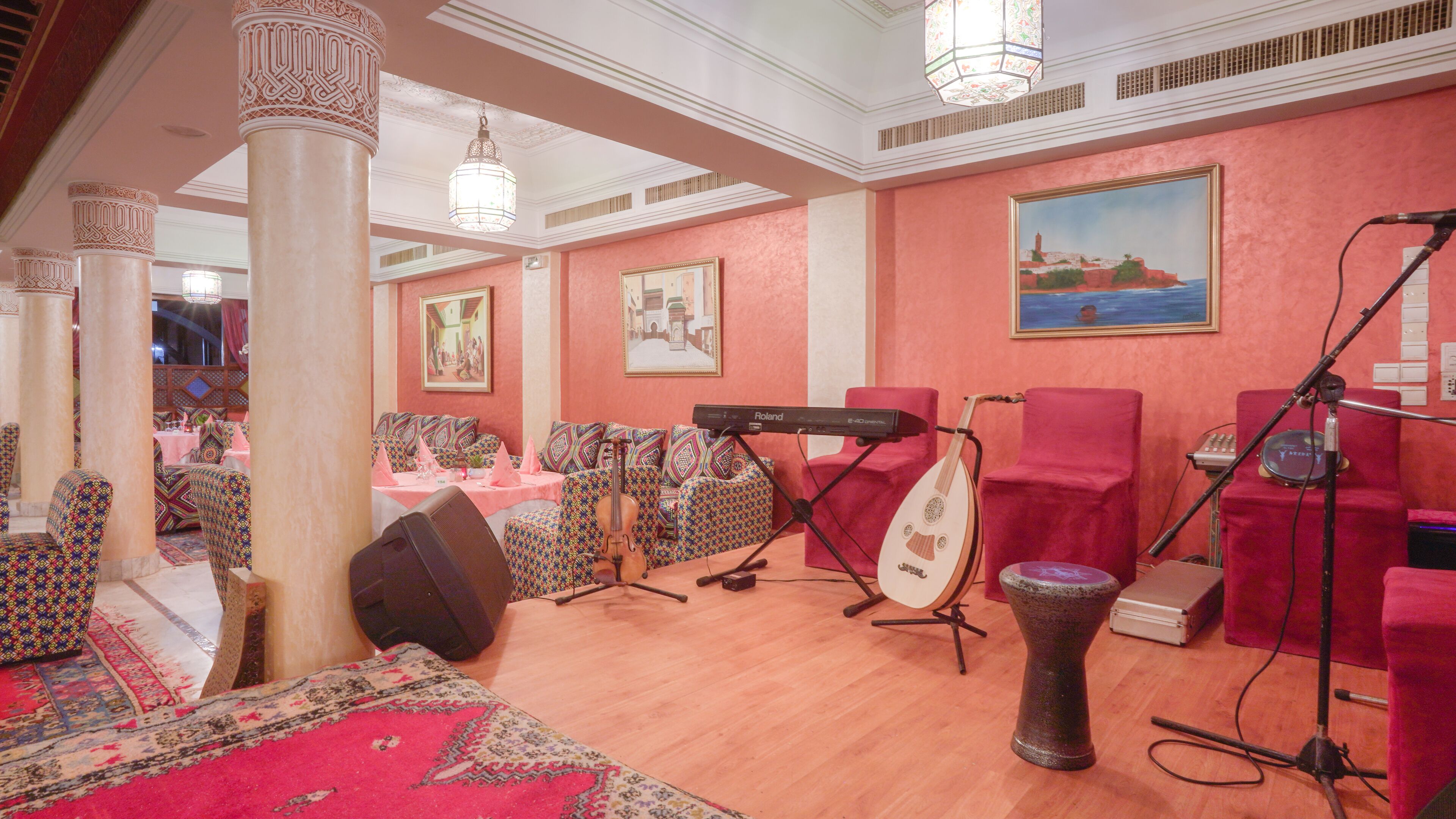 Una habitación con un piano, un instrumento de cuerda y una batería, que sugiere un salón de música o un espacio para practicar.