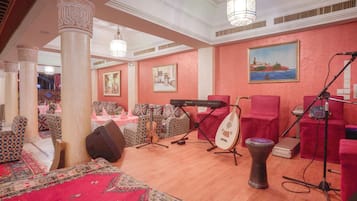 A room with a piano, a string instrument, and a drum, suggesting a music room or practice area.