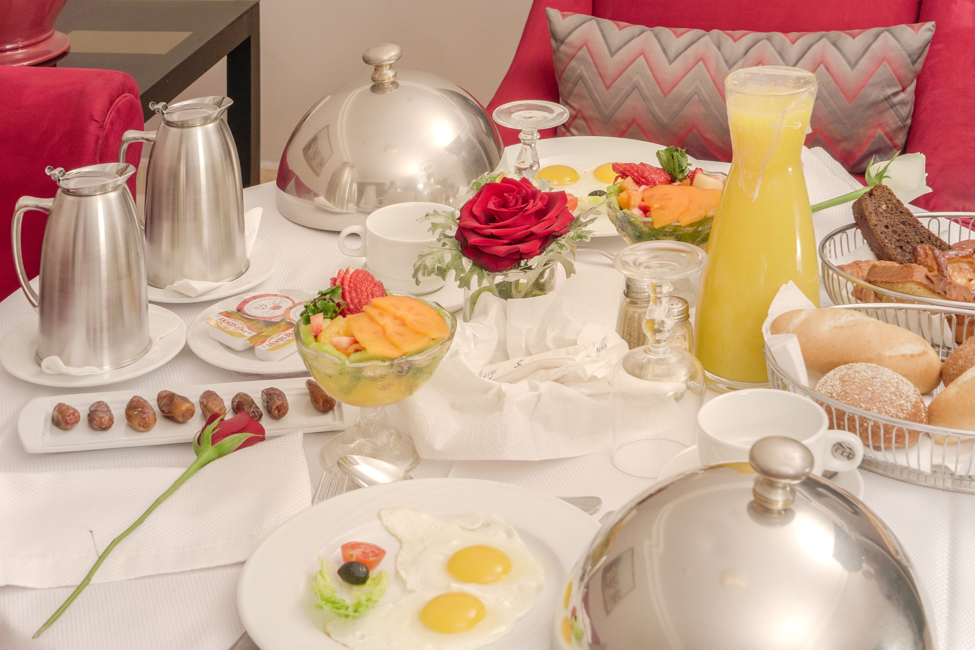 A breakfast setting with a variety of dishes, including eggs, toast, and fruit.