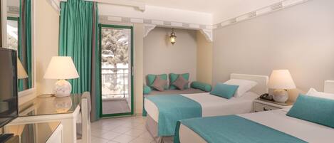 Habitación de hotel con dos camas, un escritorio con lámpara, televisión y balcón con cortinas.