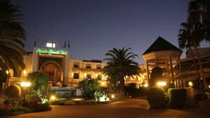 A hotel entrance with a sign reading "Grand Oasis Club," a fountain, palm trees, and a gazebo. - AGADIR BEACH CLUB HOTEL (Agadir)
