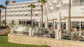 A multi-story hotel with a modern architectural design, featuring balconies and a pool area.