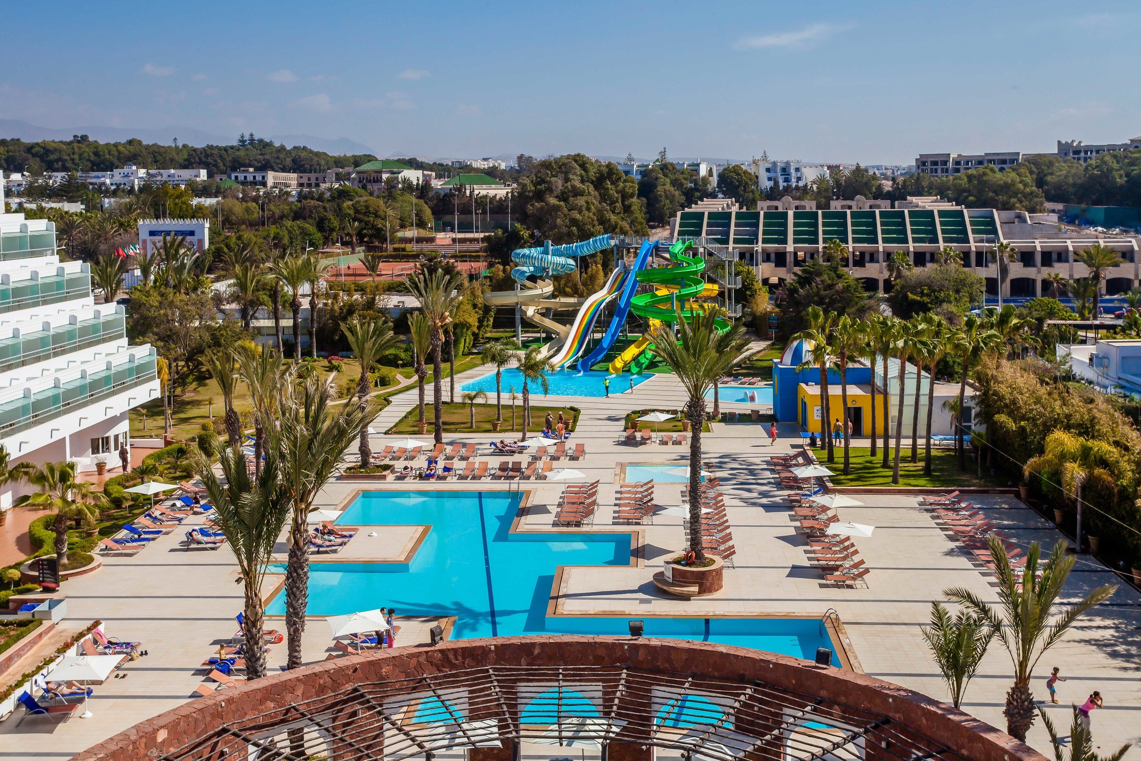 A resort with multiple swimming pools, a water park, and a variety of lounge areas.
