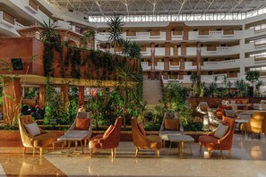 Un vaste atrium à plusieurs niveaux, avec un escalier central et différents types d’aménagements pour s’asseoir.