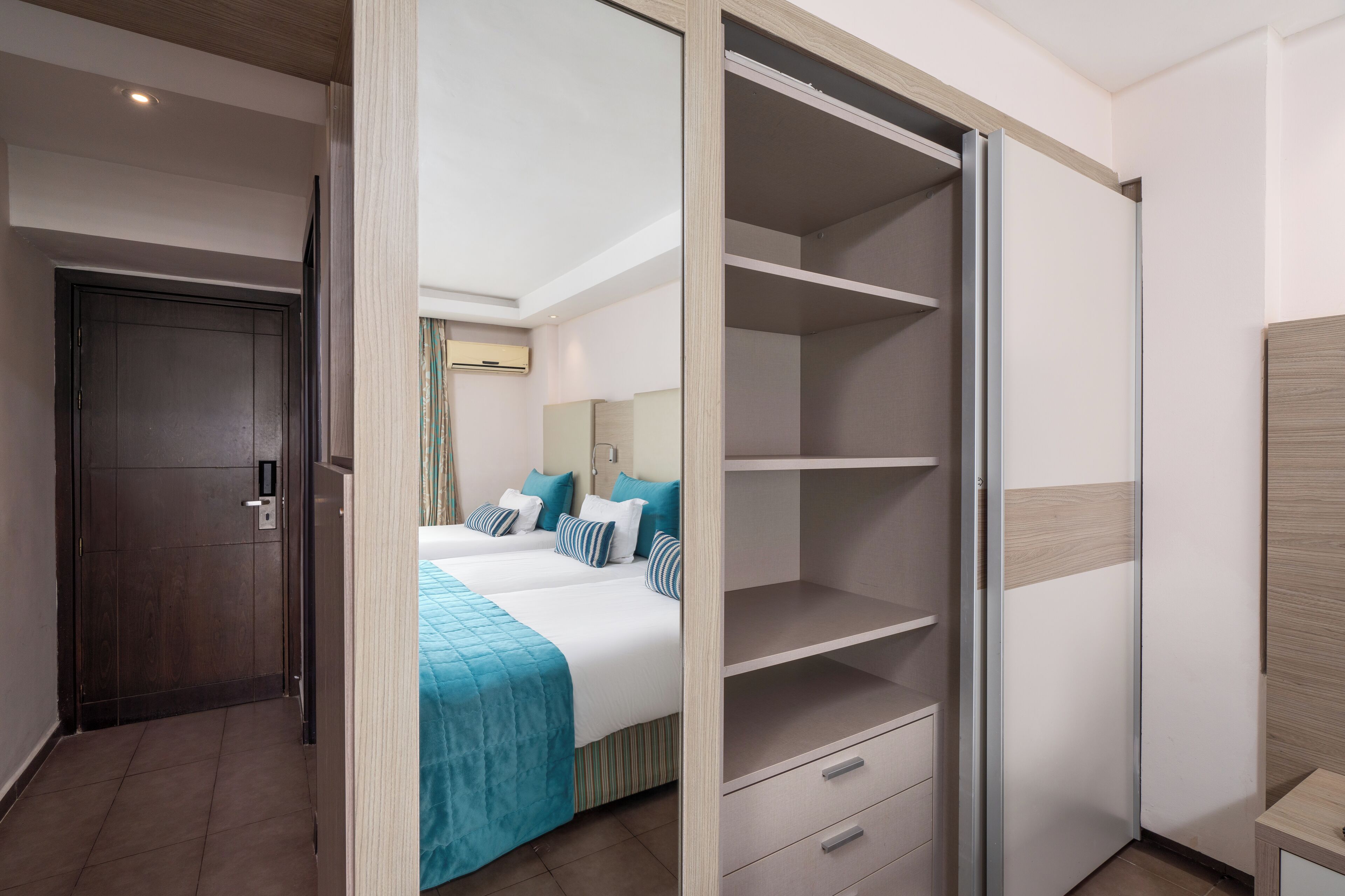 Une chambre d’hôtel avec un lit, une armoire et un bureau.