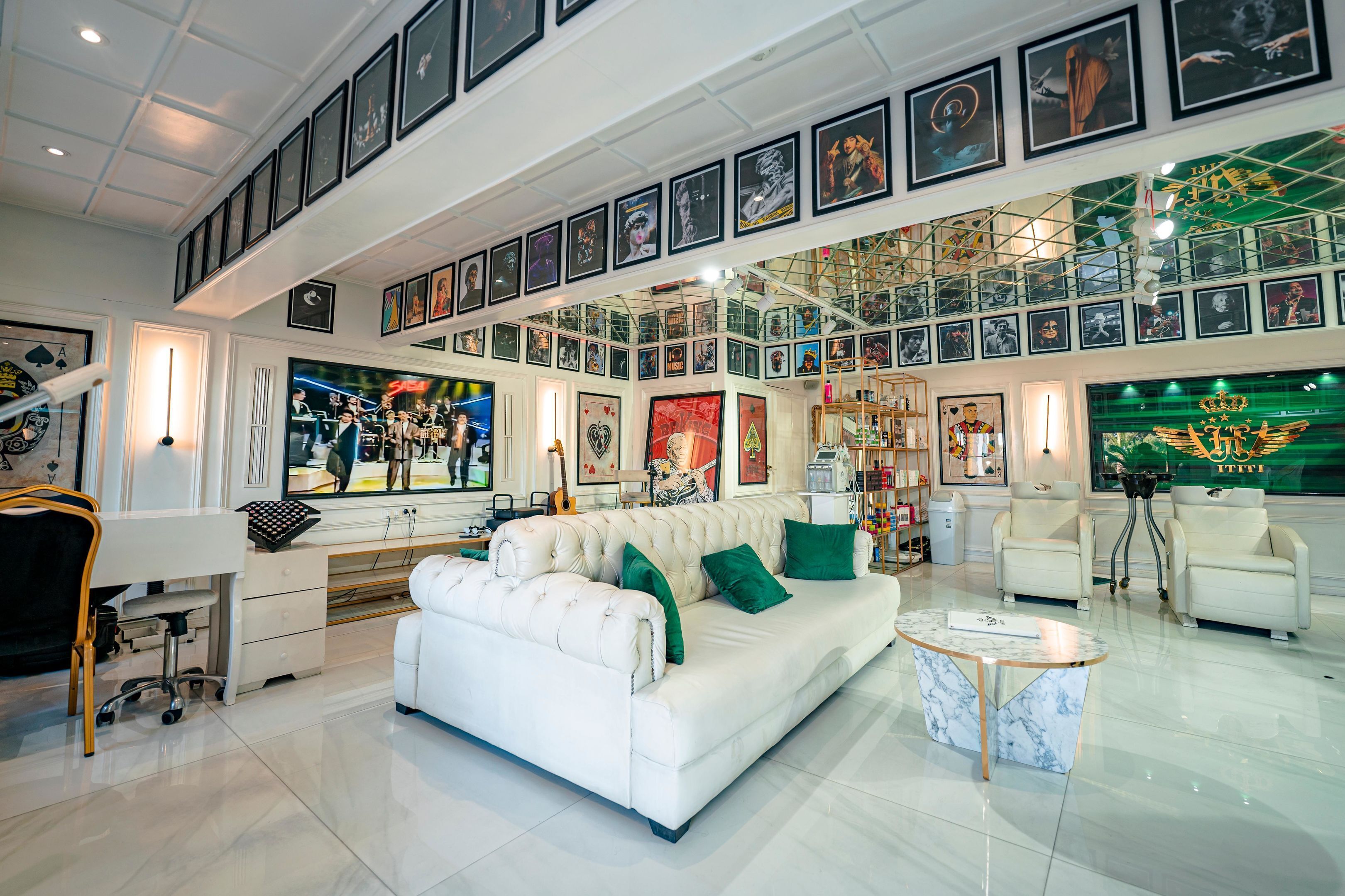 A spacious living area with a white sofa, green cushions, a marble coffee table, and a large TV screen.