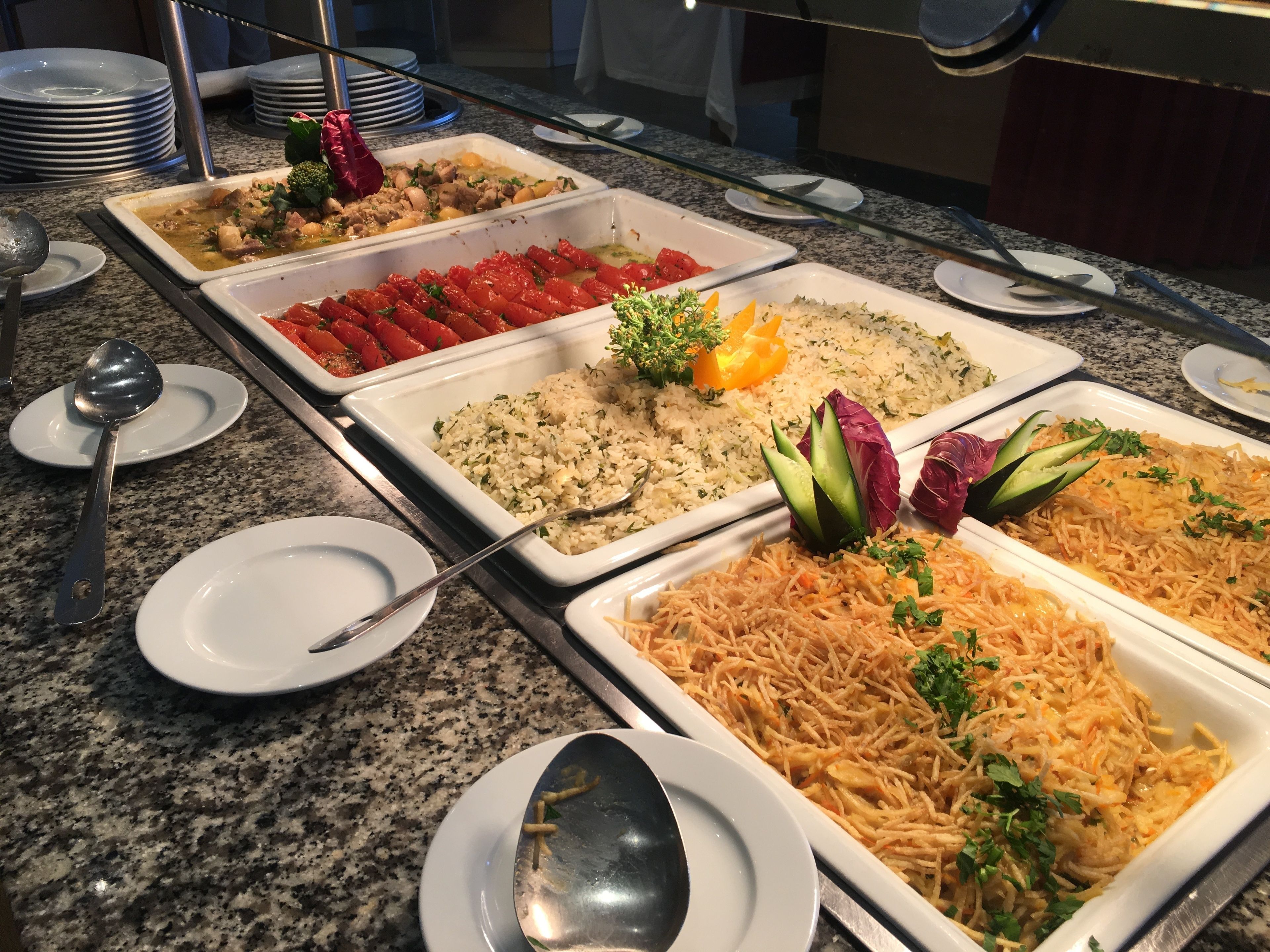 Un buffet proposant divers plats, notamment du riz, des légumes et un plat de nouilles.