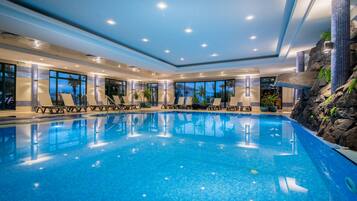 Piscine couverte, piscine extérieure, parasols de plage, chaises longues