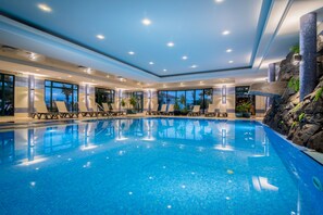 Piscine intérieure, piscine extérieure, parasols, chaises longues