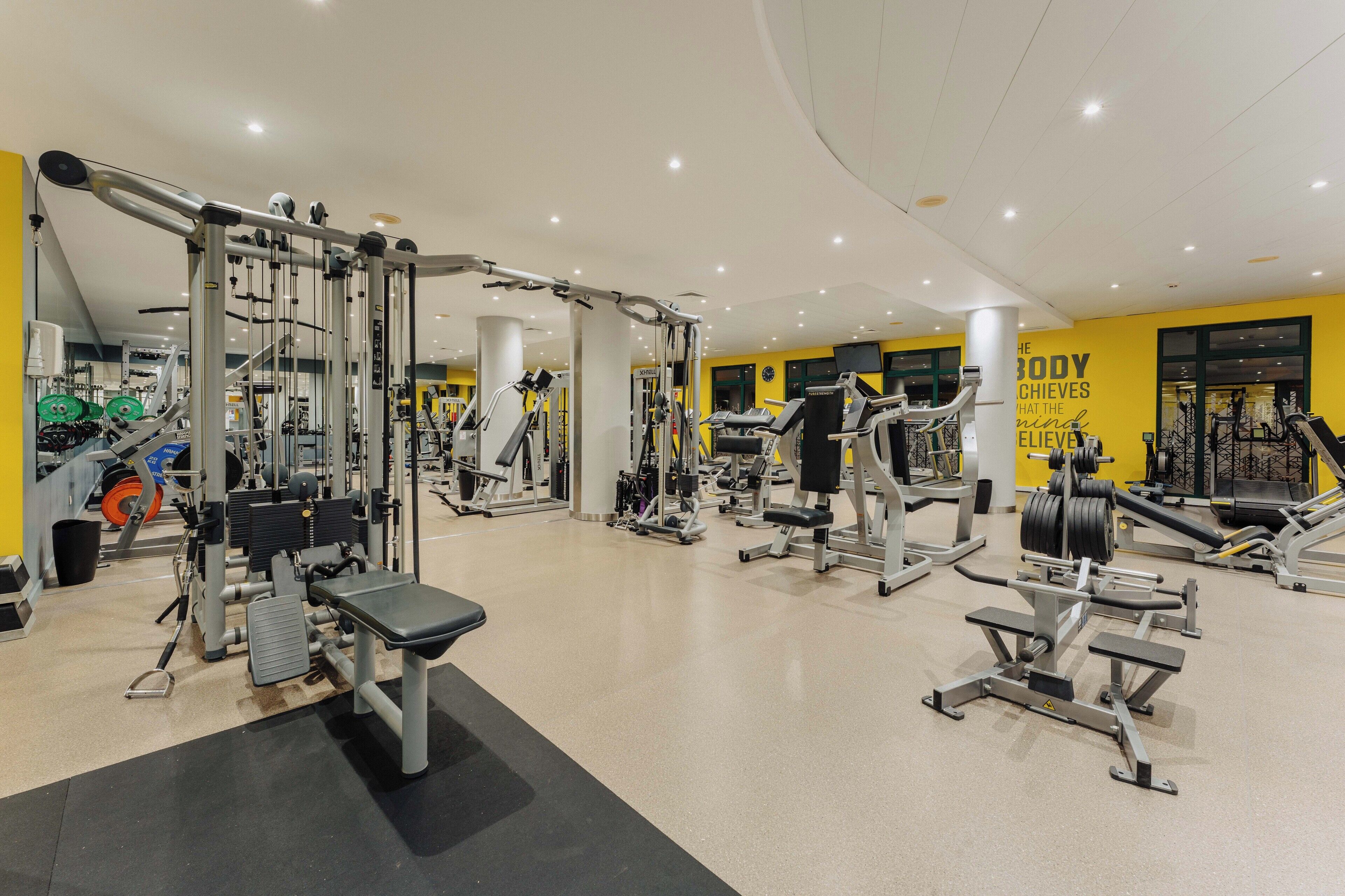 A gym with various exercise equipment, including weight machines and free weights.