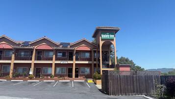Un hotel a più piani con un evidente cartello 'Valley Inn', numerosi balconi e un parcheggio di fronte.