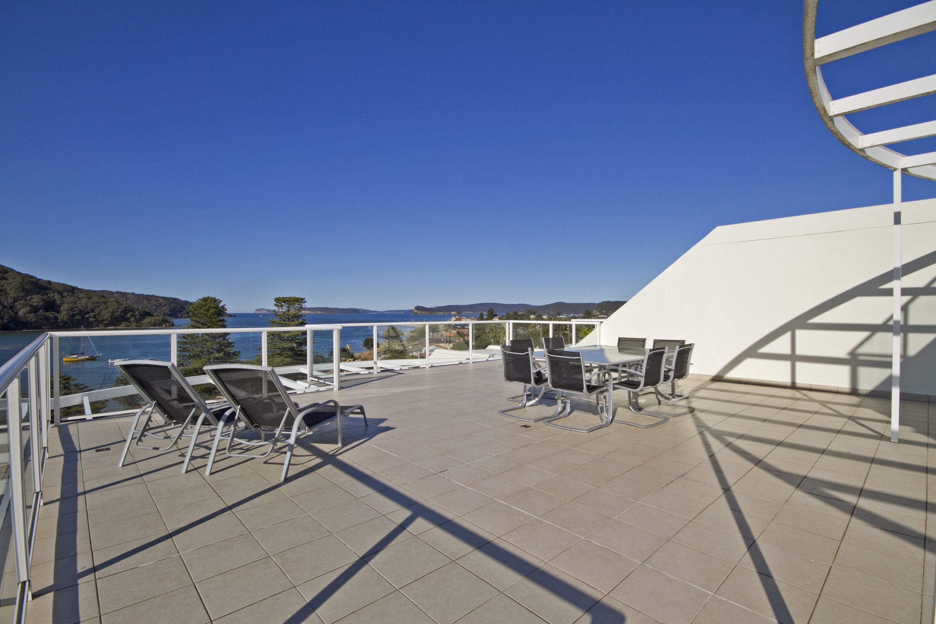 A terrace with outdoor seating and a view of the sea.