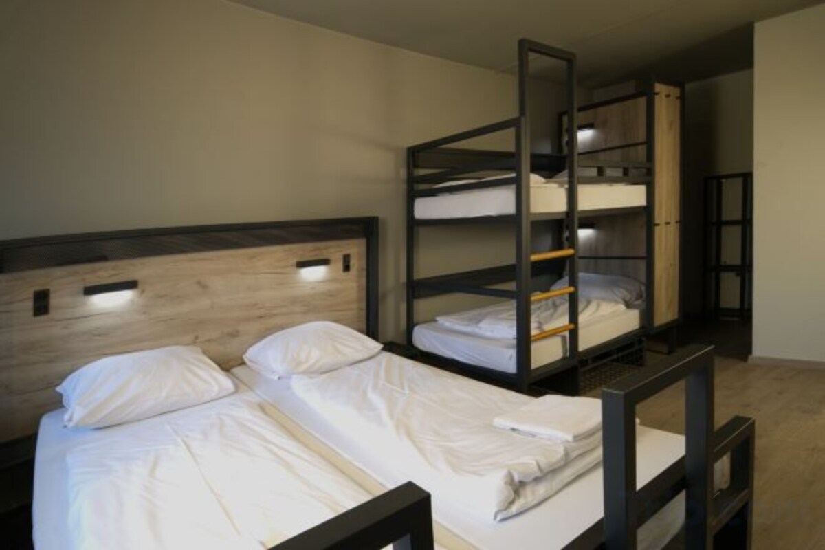 Ein Zimmer mit Etagenbetten, einem Holz-Kopfteil und einer Schrankwand.
