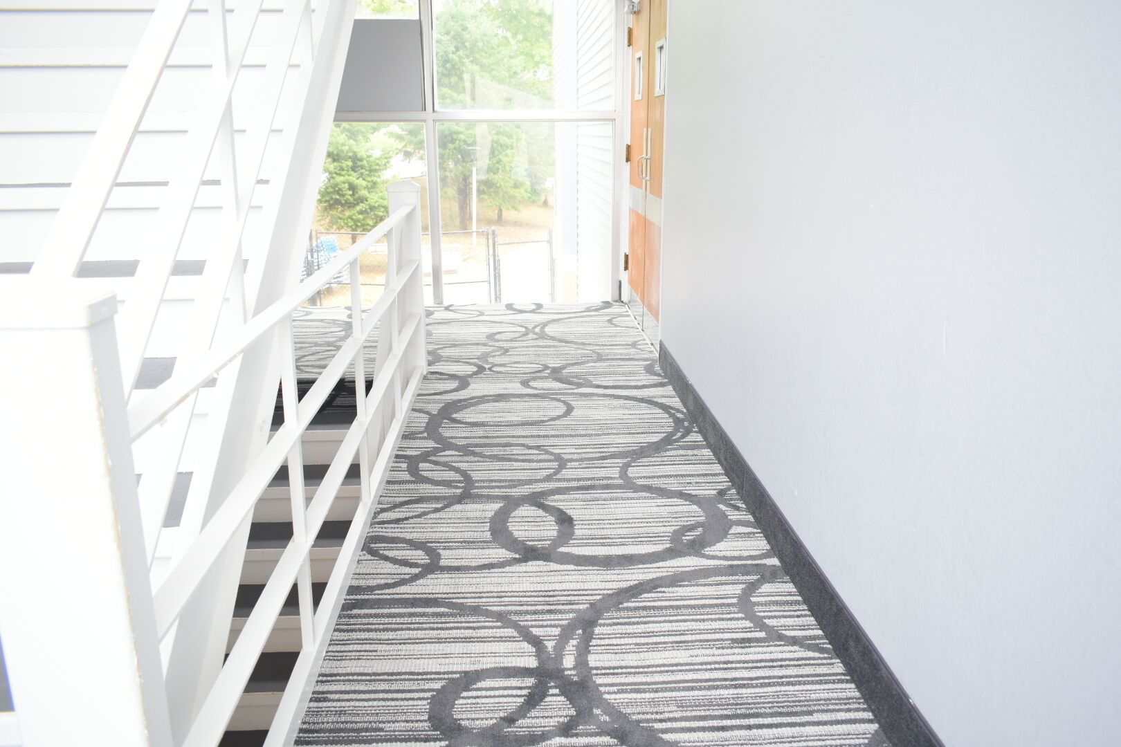 Un escalier recouvert d’une moquette à motifs menant à un palier.