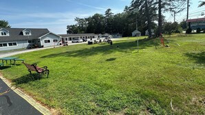 A grassy area with a bench, picnic table, and a playground with swings and a slide. - Pilgrim Inn & Cottages (Plymouth)