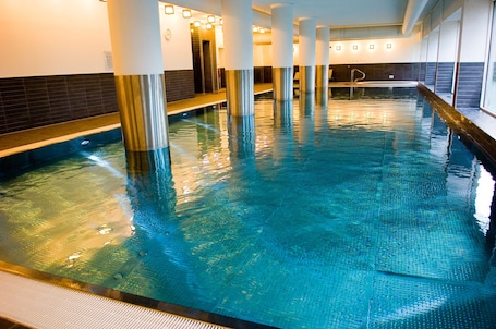 Una piscina techada, sillones reclinables de piscina