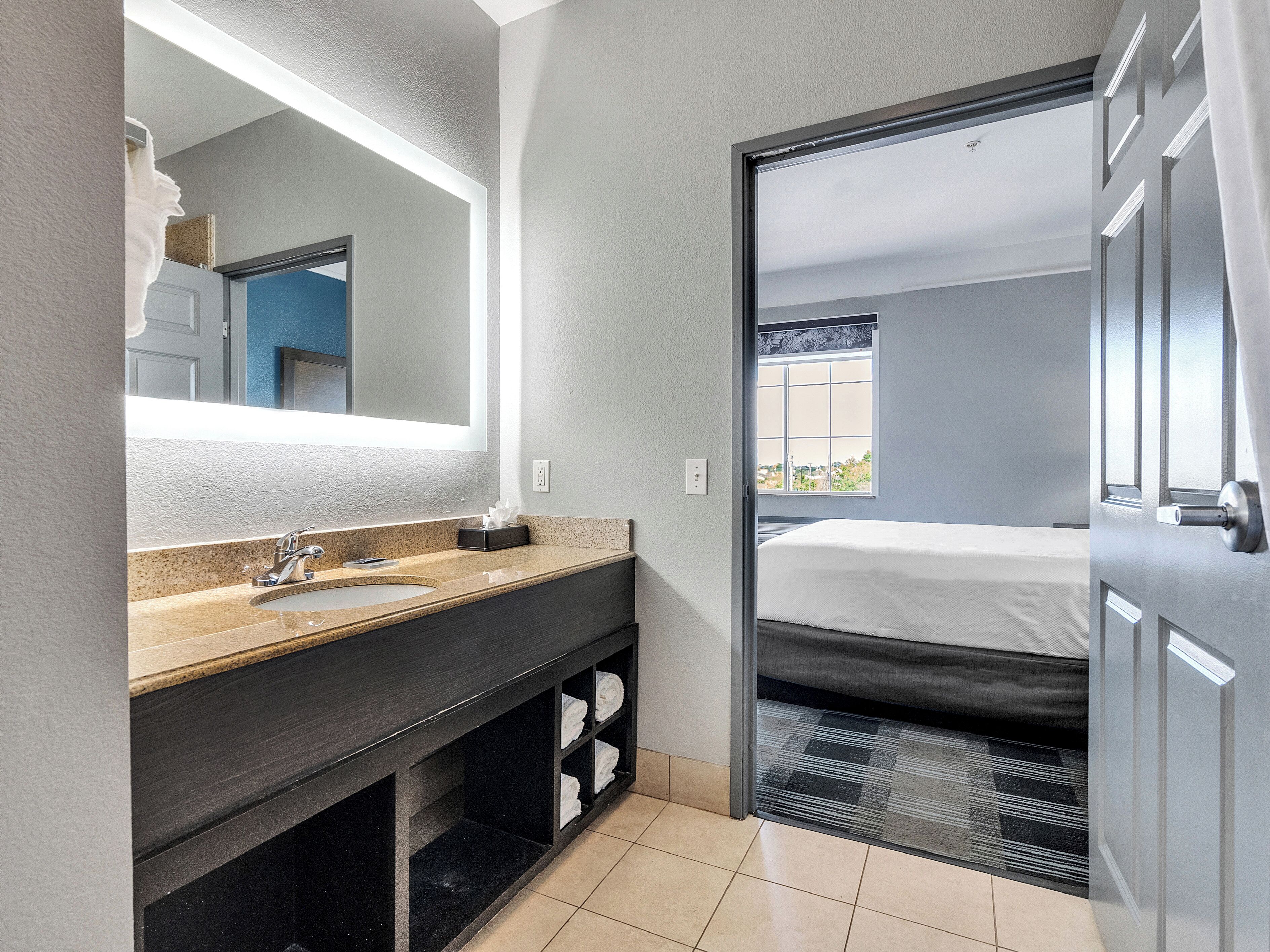 A modern bathroom with a double sink, a large mirror, and a towel rack.