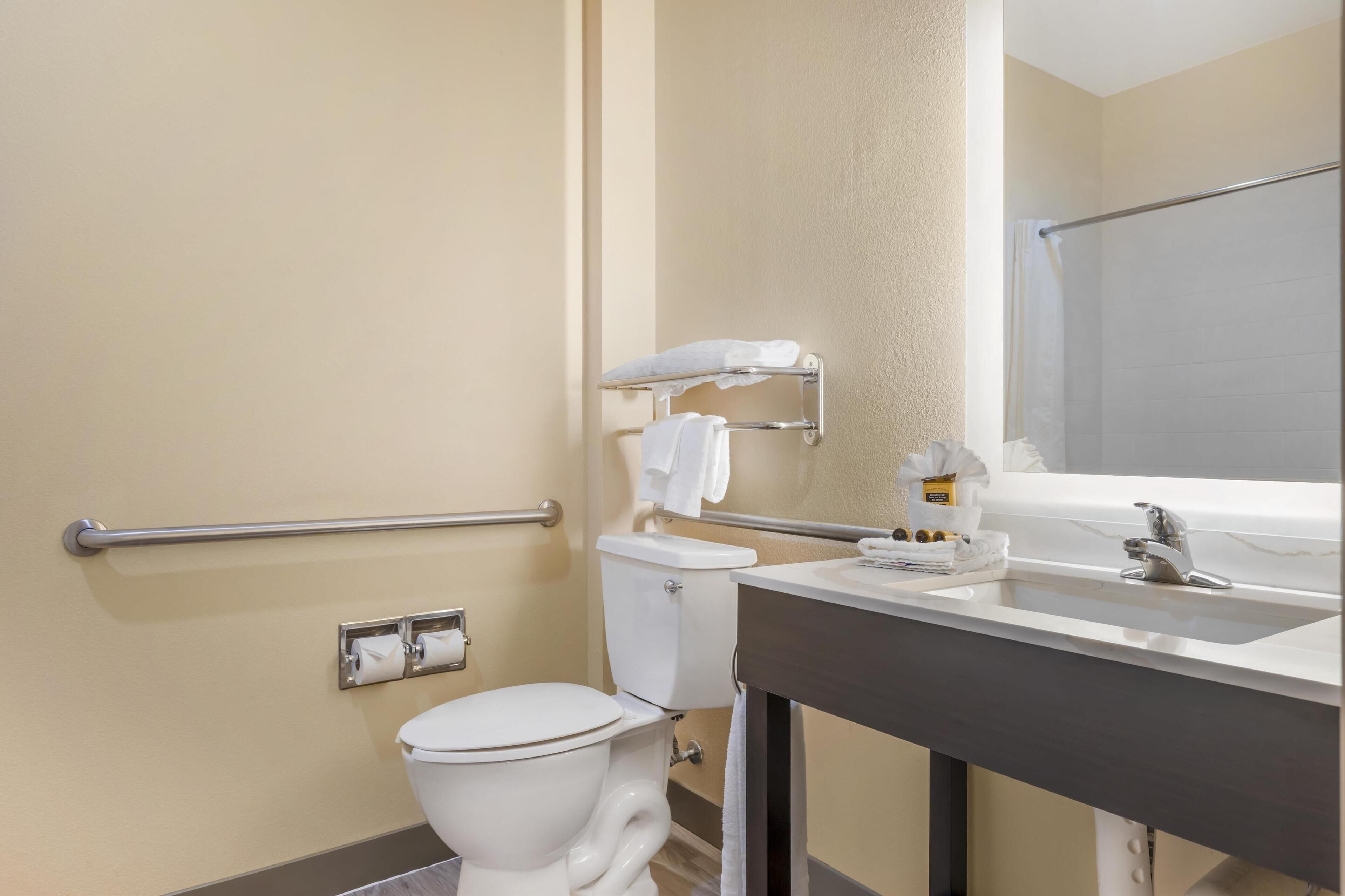A bathroom with a toilet, a sink, a towel rack, and a shower curtain.