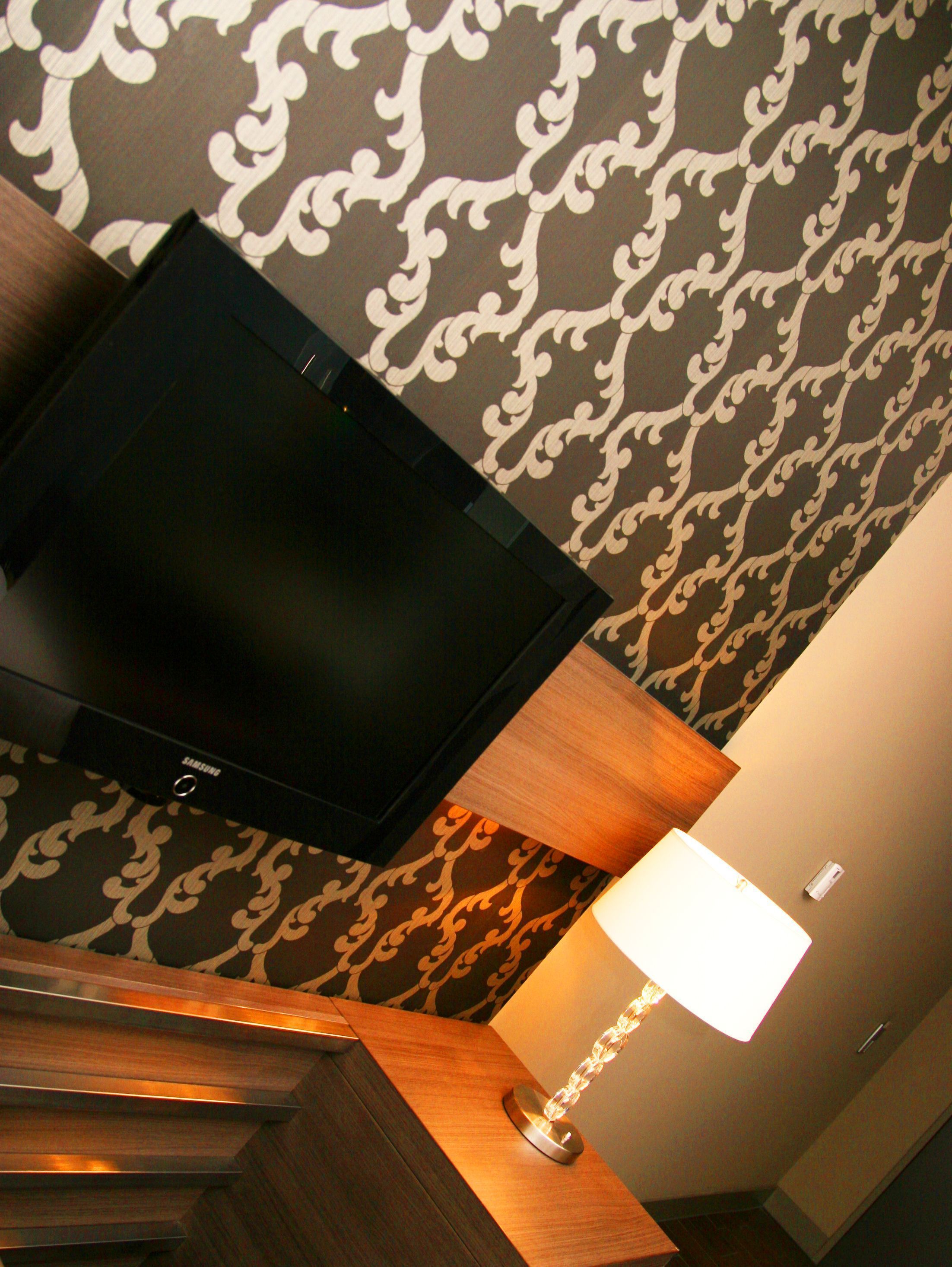 Un televisor montado en la pared, con un diseño de papel tapiz estampado.