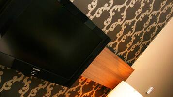 Un televisor montado en la pared, con un diseño de papel tapiz estampado.