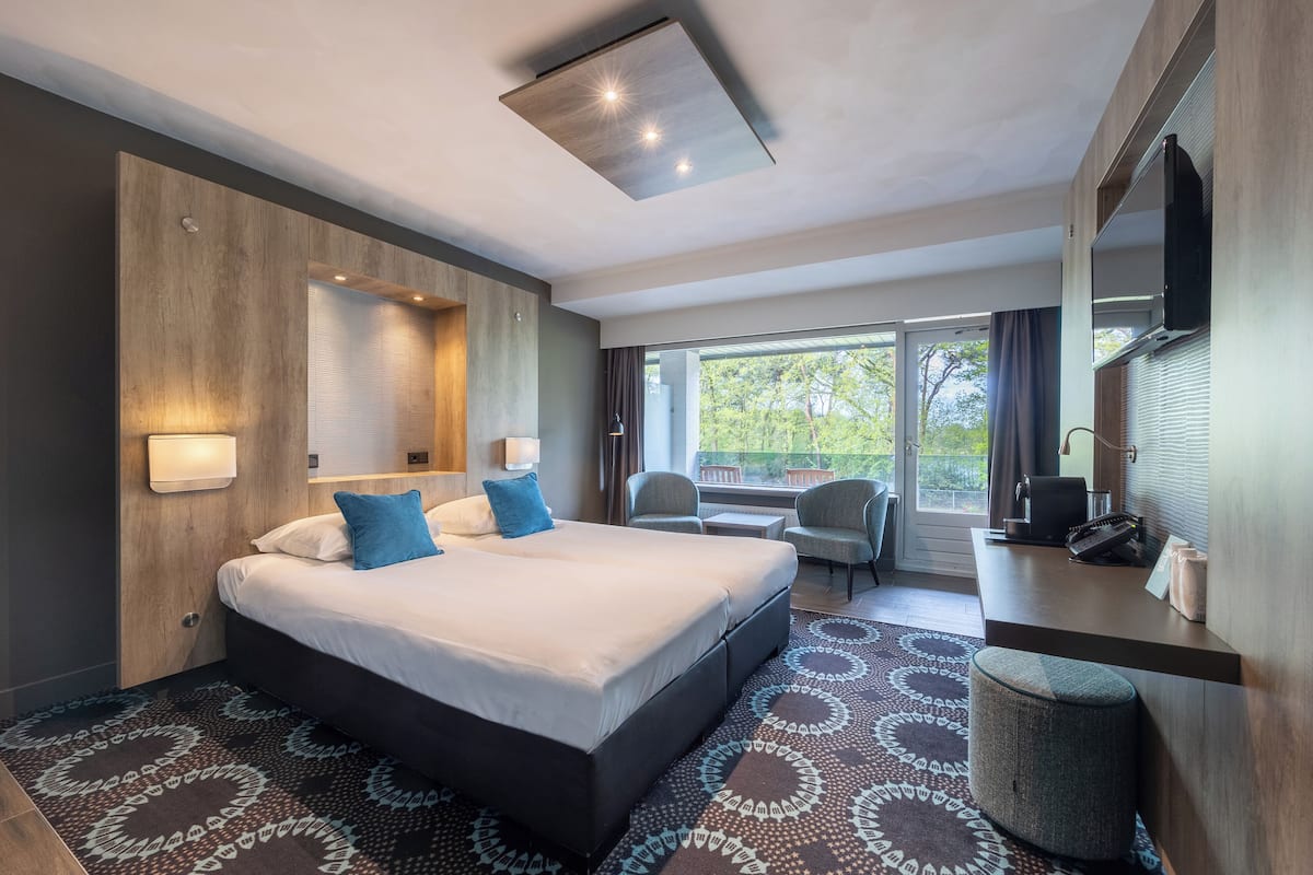 Une chambre d’hôtel moderne dotée d’un grand lit, d’un bureau et d’un coin salon.