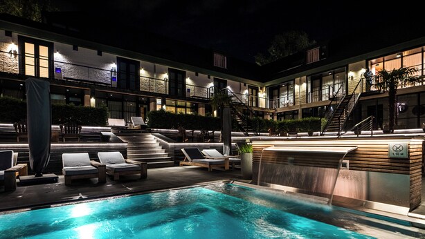 A swimming pool with lounge chairs, a hot tub, and a staircase leading to an upper level. - Van der Valk Hotel Gilze - Tilburg (Gilze)