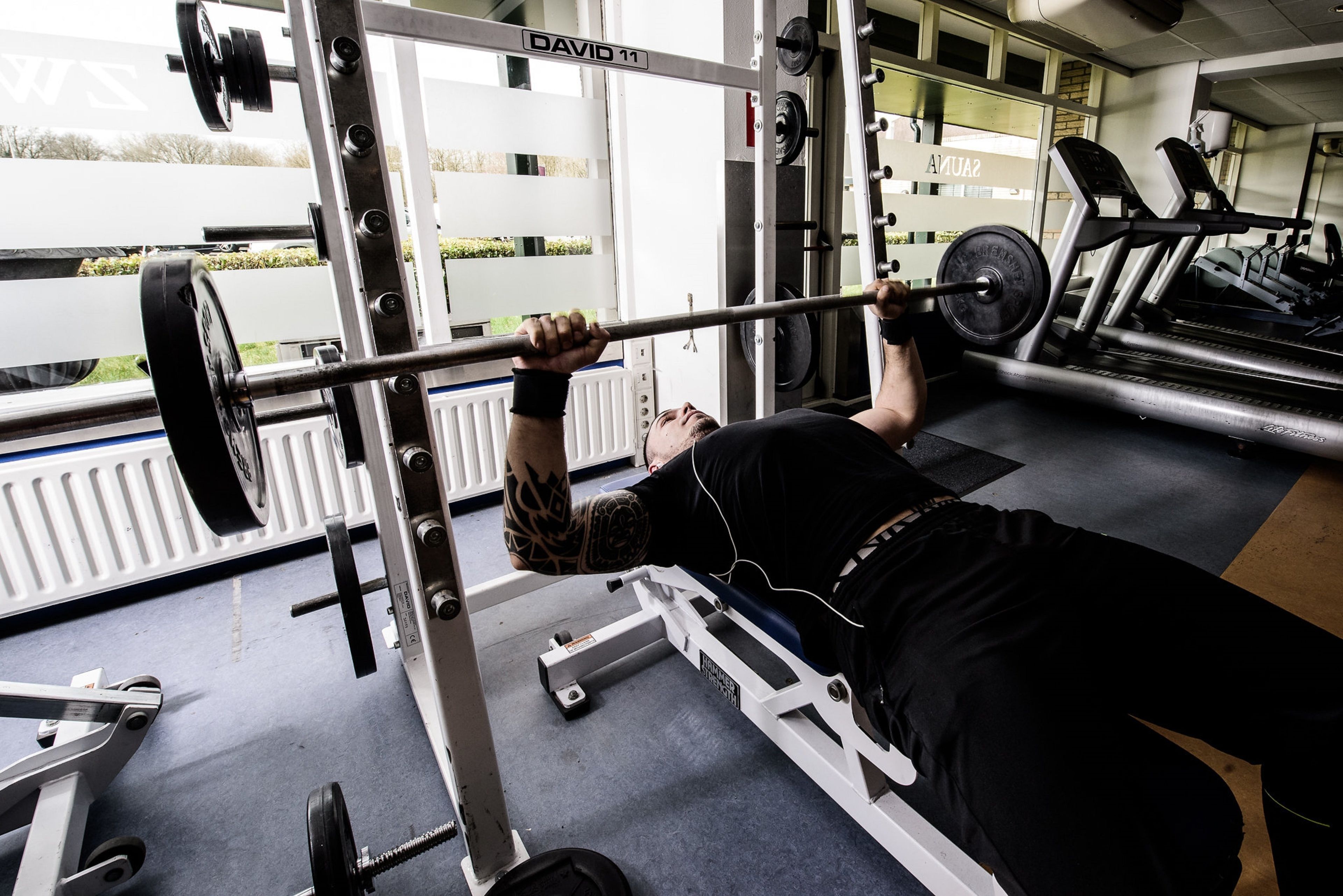 Un gimnasio con banco de pesas, cinta de correr y diversos equipos de ejercicio.