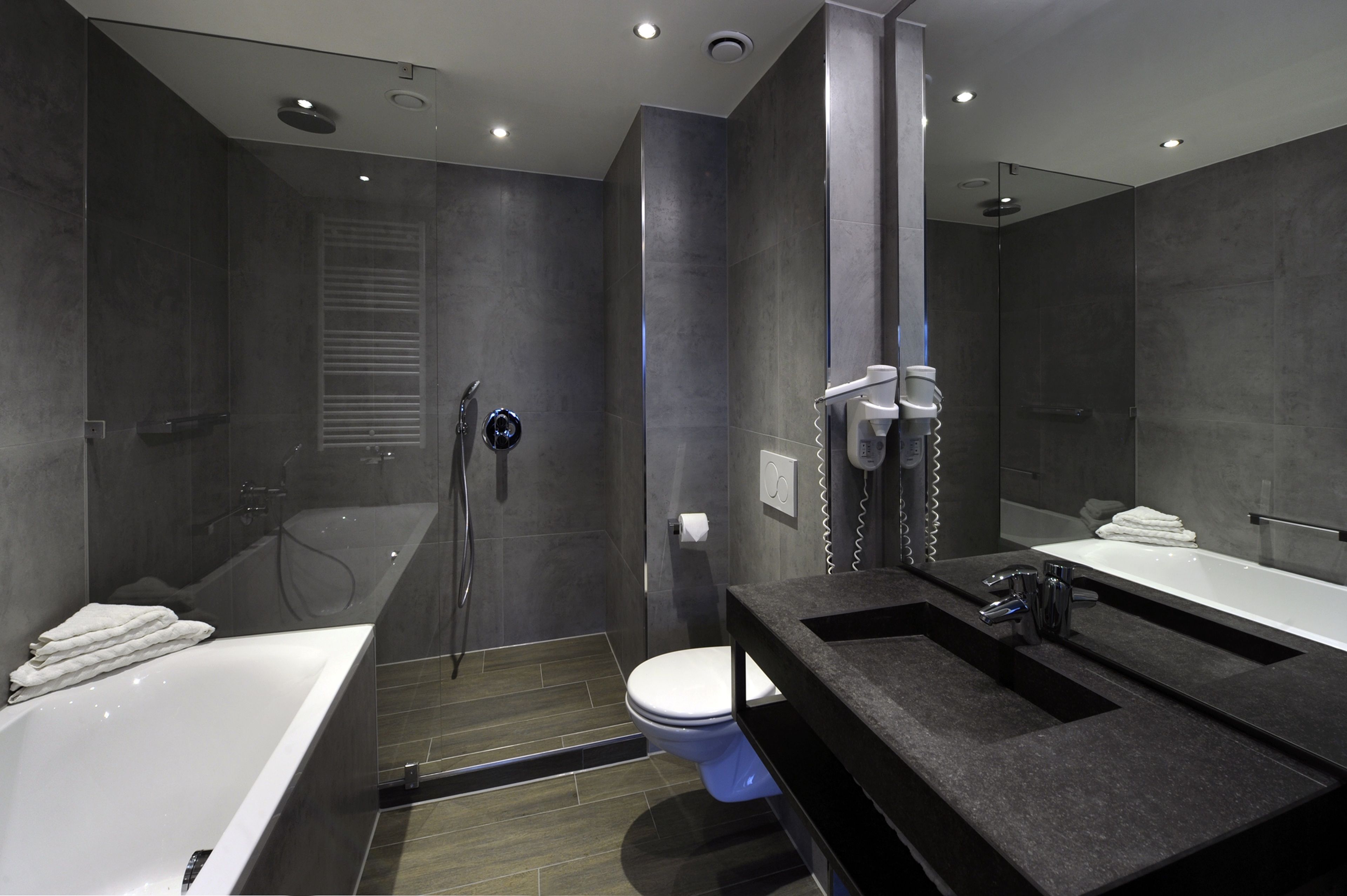 Un baño moderno con bañera, inodoro y zona de ducha.