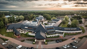 An aerial view of a hotel with multiple buildings, parking areas, and surrounding greenery. - Van der Valk Hotel Gilze - Tilburg (Gilze)