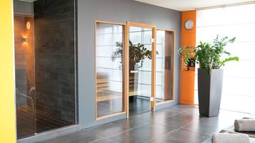 Relax in a stylish space with a walk-in shower, seating area, and lush greenery.