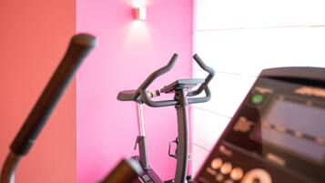 An exercise bike with a digital display and a wall-mounted light.