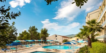 Una piscina al aire libre de temporada, sombrillas