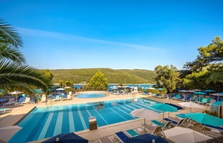Una piscina al aire libre de temporada, sombrillas