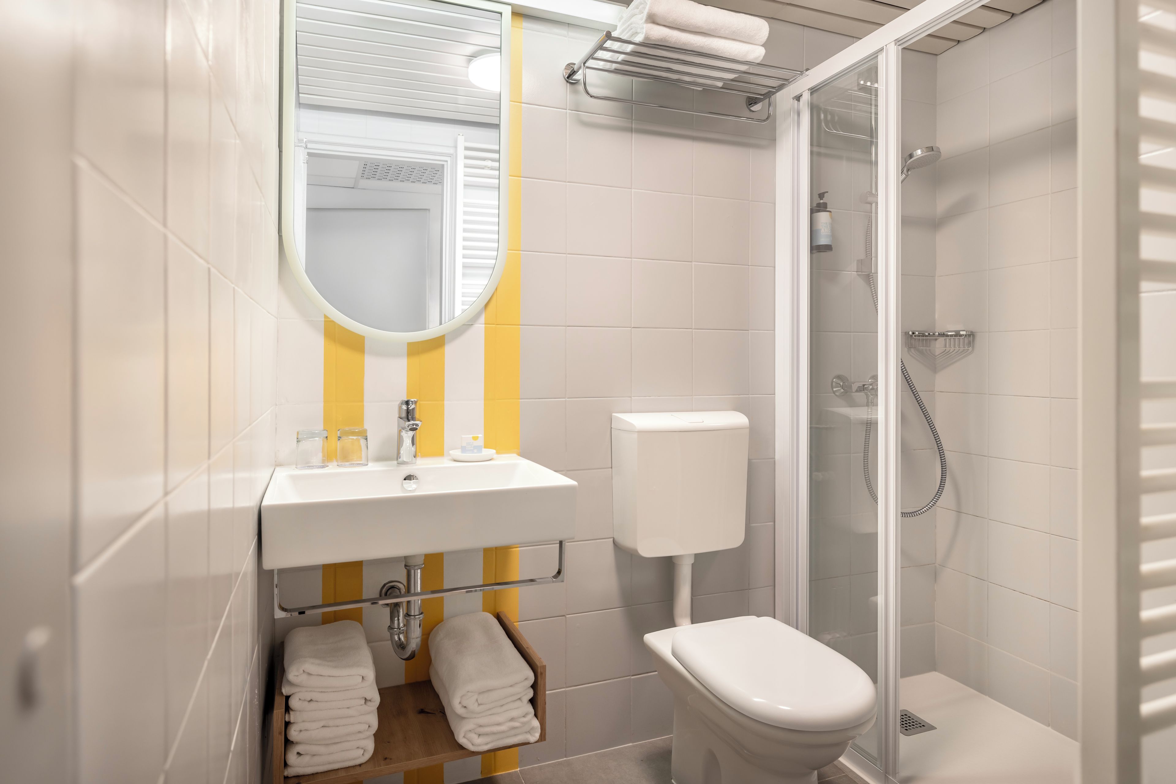 A modern bathroom with a toilet, sink, and shower.