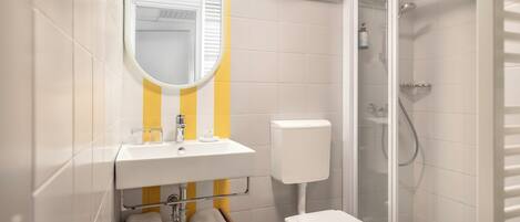 A modern bathroom with a toilet, sink, and shower.