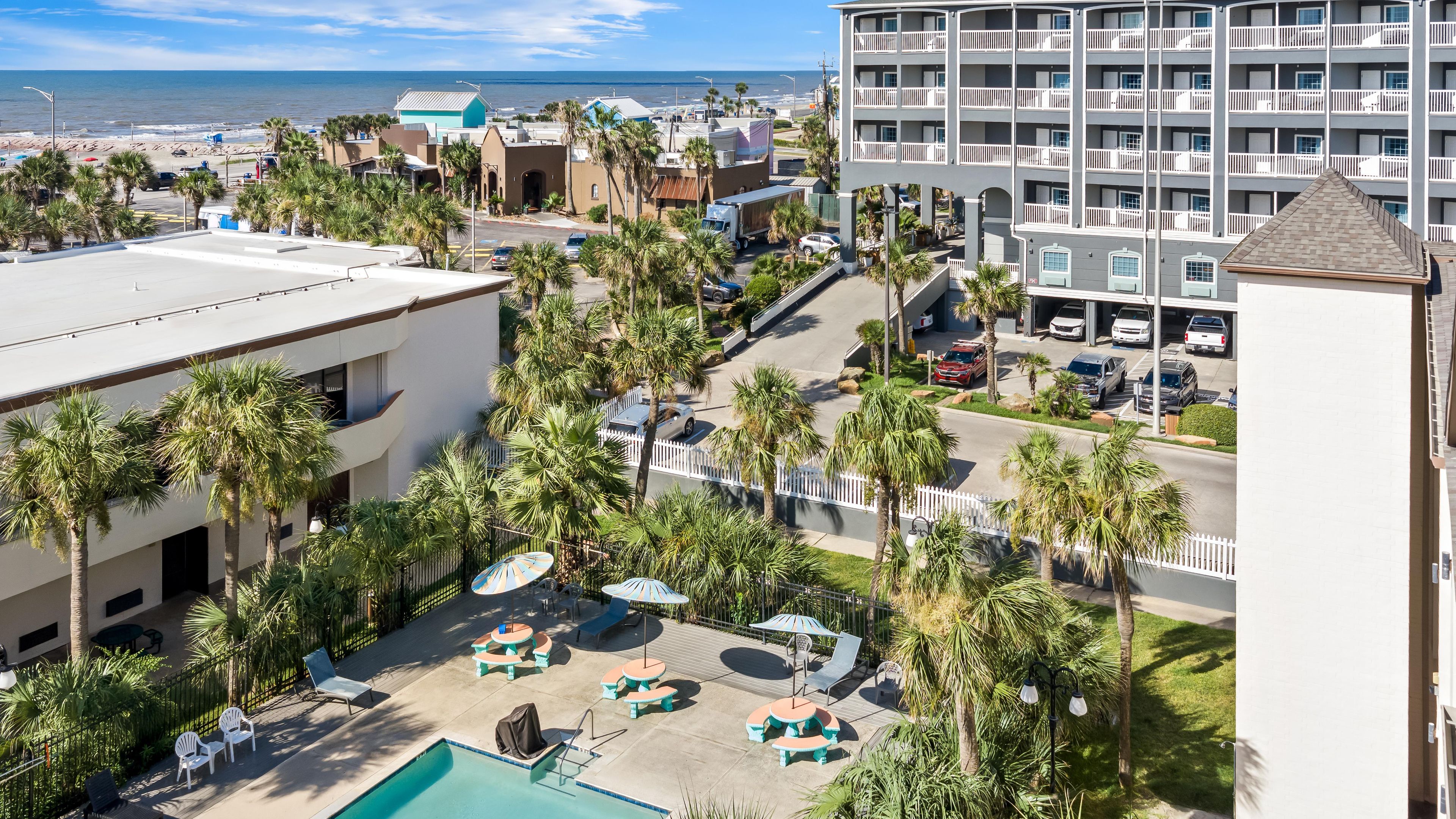 Un resort con zona de piscina, mobiliario exterior y vistas a la playa.