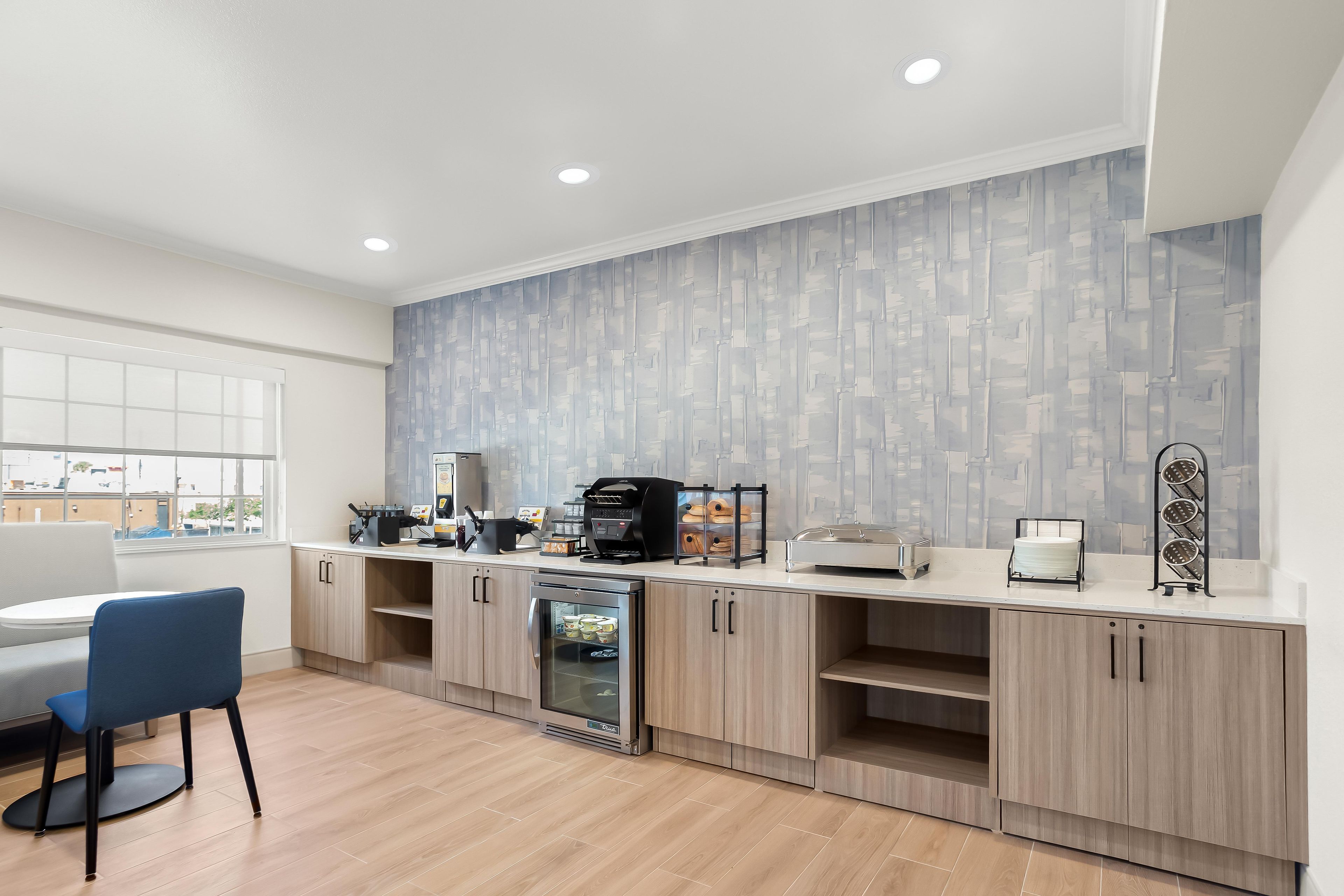 A modern kitchen with a built-in oven, a coffee machine, and a refrigerator.